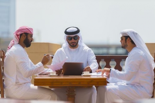 Arab men sitting outside during a business meeting |