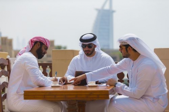 Business men sitting outside during a meeting with a background of a well-known landmark|