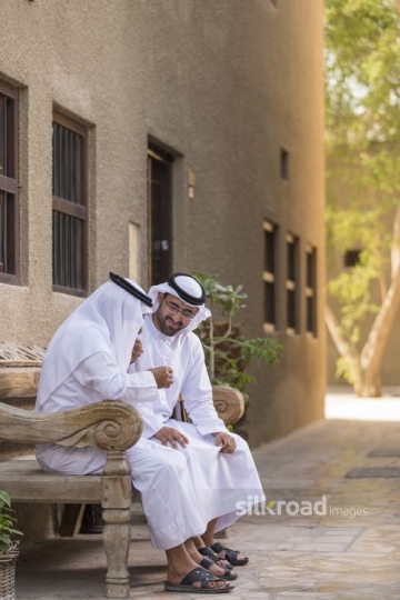 Arab men sitting on the bench sitting together|-