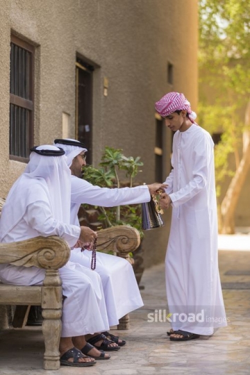 Arab man offering coffee to the Arab men|-