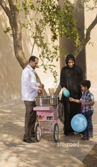 Arab boy taking cotton candy from the man|-