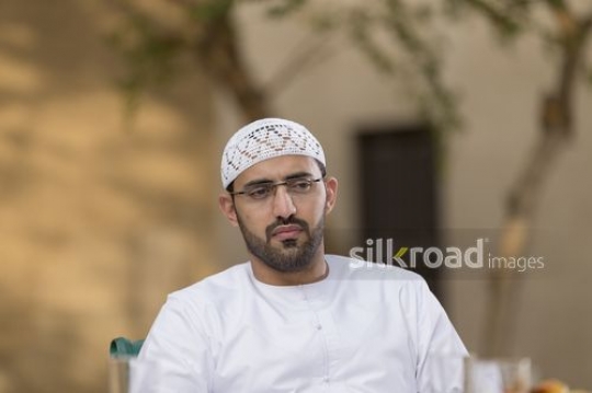 Arab man sitting down|-