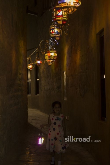 Arab girl walking carrying a Ramadan Lantern|-