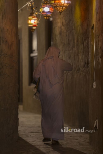 Arab man strolling through a lantern lit alleyway |-