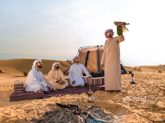 man standing and lifting falcon