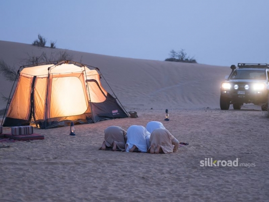 Men bending over in prayer