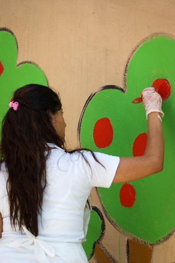 female volunteer drawing on the wall