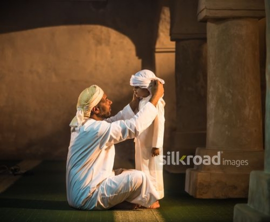 Fixing headdress of little boy|-