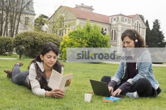 Women on the grass studying|