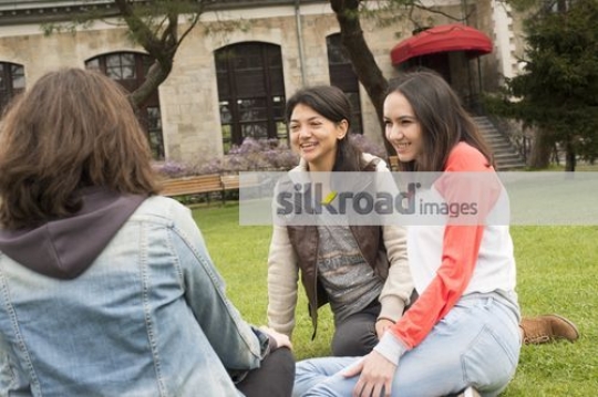 Women sitting together outside talking|