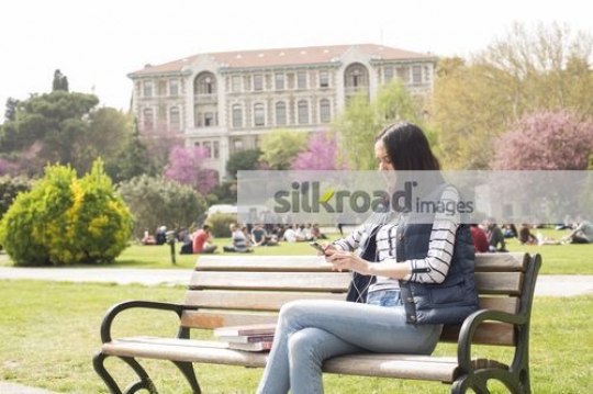 Woman sitting on the bench using her mobile|