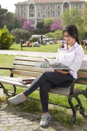Woman sitting on the bench reading a book|