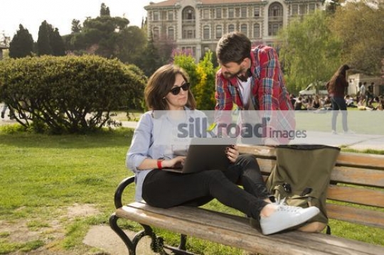 University Student sitting on the bench talking to a Student