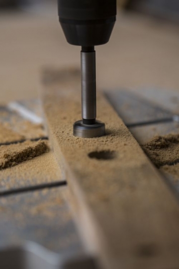 Cut a circular hole through the wood