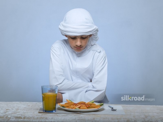 Arabian boy patiently waiting to be served
