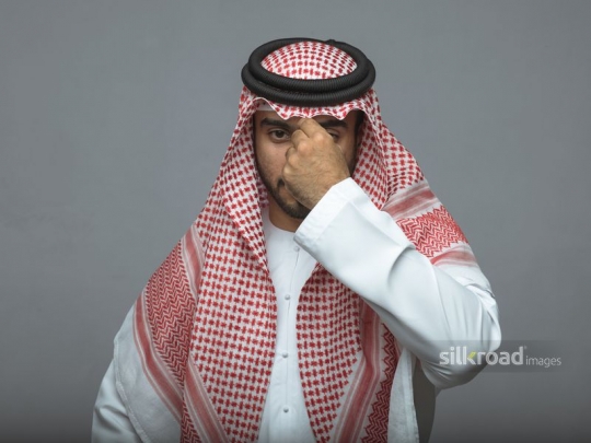 Arabian man fixing his traditional head cover attire