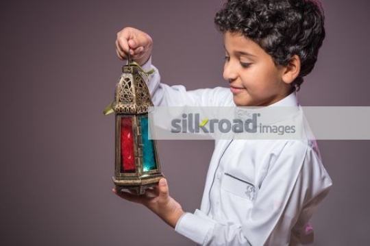 Young Middle Eastern boy carrying the Ramadan Lantern|