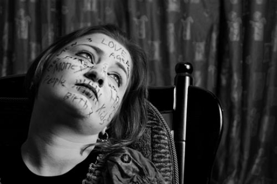 black and white image for woman with words written on her face