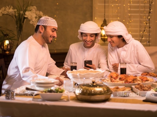 Father with sons around dining table|-