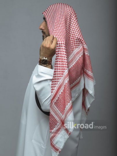 Side view of an Arabian man fixing his head cover