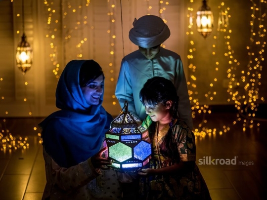 Mother and children playing with lantern|-