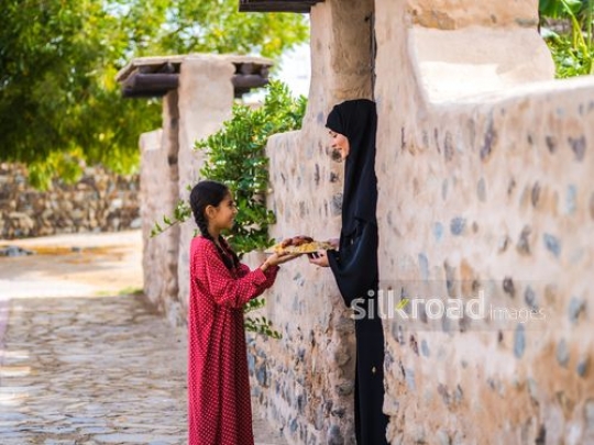 Girl giving plate to woman|-