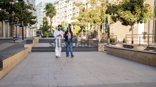 Professional Man and Woman Smiling with Coffee in Al Abdali Boulevard