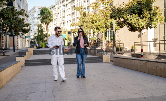 Professional Man and Woman Smiling with Coffee in Al Abdali Boulevard