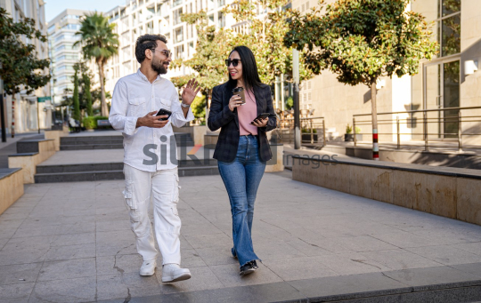 Professional Man and Woman Smiling with Coffee in Al Abdali Boulevard