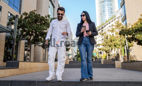 Professional Man and Woman Smiling with Coffee in Al Abdali Boulevard
