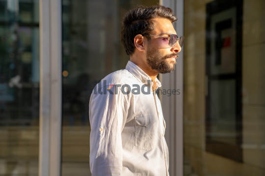 Professional Man Walking Past Glass Door in Morning Light at Al Abdali Boulevard