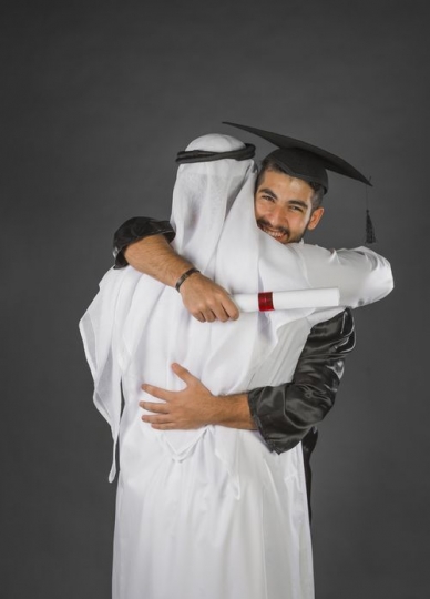 An Arab father hugging his son on his Gradutaion|-