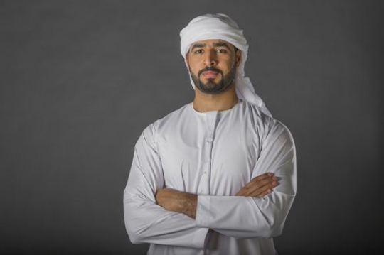 Middle Eastern Businessman dressed in the traditional attire arms crossed|