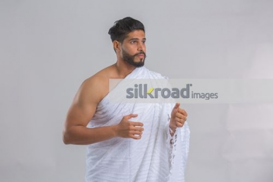 Medium shot of an Arab man dressed in the religious attire|