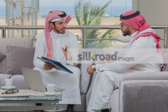 Middle Eastern Employees talking to each other|