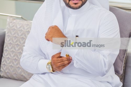 Business man closing the cufflink