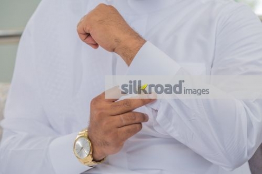Arab man fixing the cufflink|