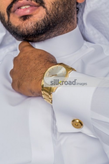 Middle Eastern man fixing his kandoura|