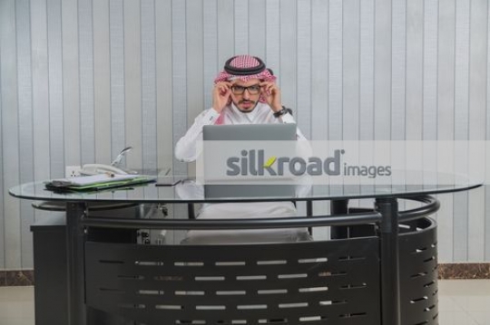 Businessman fixing his glasses|