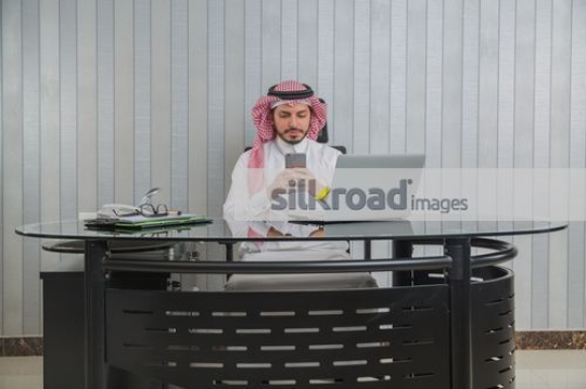 Man texting sitting at the office desk|