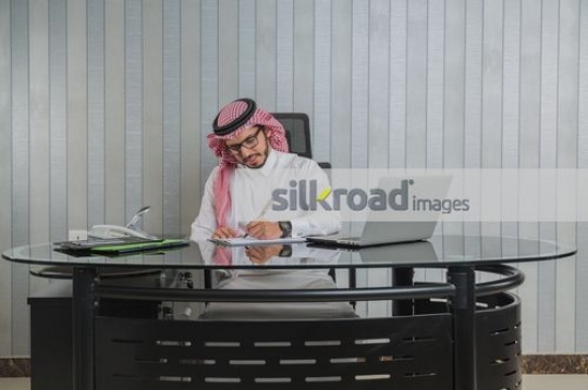 Arab Businessman sitting at his desk at the office working|
